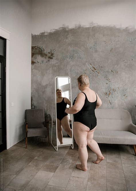Blonde Woman Looking At Reflection In Mirror By Stocksy Contributor