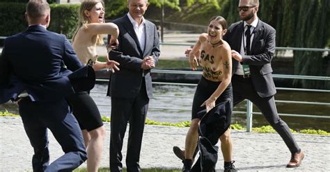 Allemagne Olaf Scholz surpris par deux militantes qui posent seins nus à côté de lui