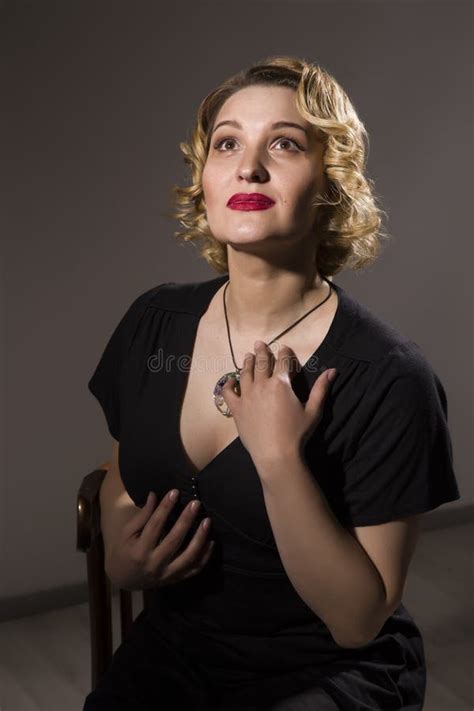 Retro Portrait Of Beautiful Woman In Black Dress Sitting On The Chair