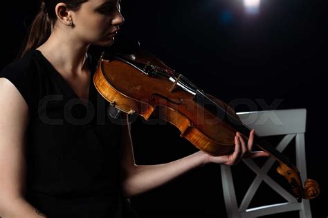 Beautiful Female Musician Playing On Violin On Black With Back Light