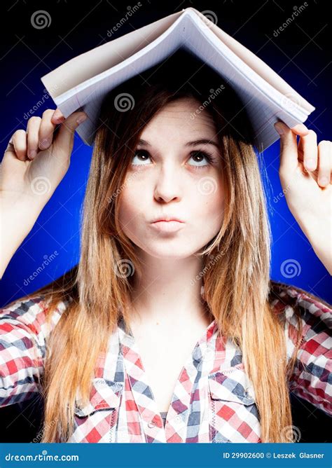 Confused And Puzzled Young Girl Holding Exercise Book On Her Head Stock