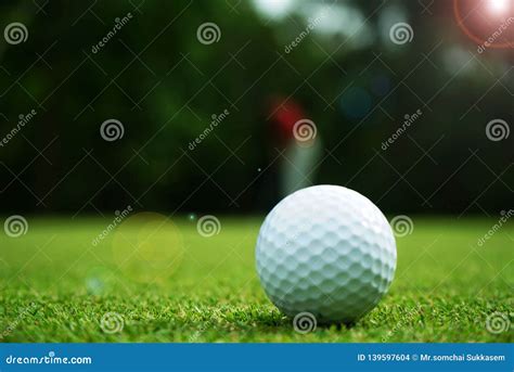 Blurred Golf Ball On Green In Beautiful Golf Course With Sunset Stock