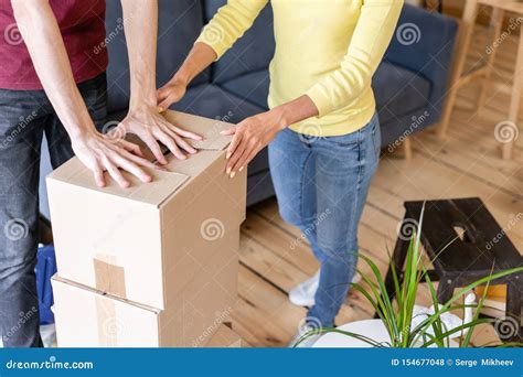 Close Up Of Hand Packing Cardboard Box Concept Moving House Young