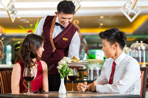 Waiter Serving Dinner In Elegant Restaurant — Stock Photo © Kzenon