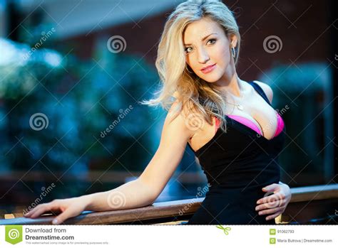 Очень красивая и сексуальная блондинка девушки с сочным бюстом в черном Д р Стоковое Изображение
