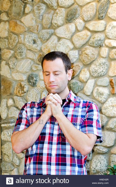 Man praying alone with hands clasped together Stock Photo - Alamy