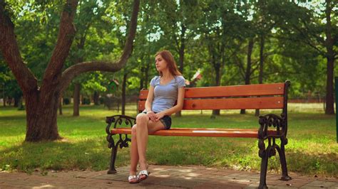 Girl sitting on a bench waiting for someone - Free Stock Video