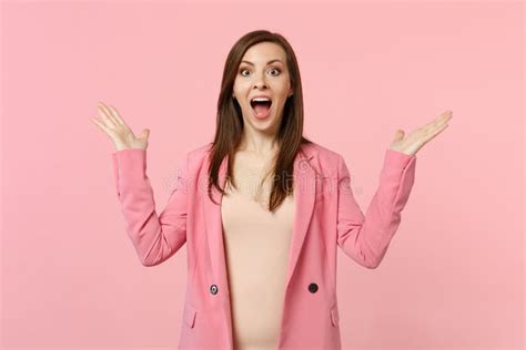 Portrait Of Excited Young Woman In Jacket Keeping Mouth Wide Open Spreading Hands Isolated On