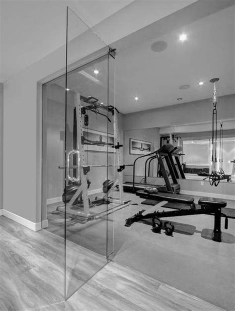 An Exercise Room With Mirrors And Equipment In Black And White