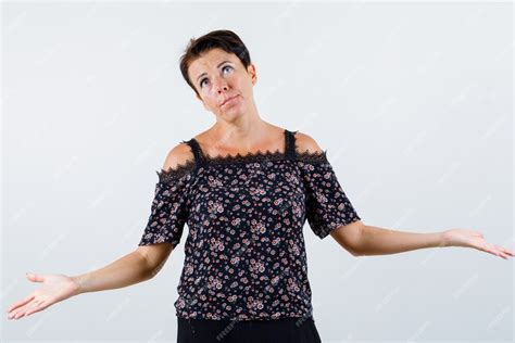 free photo mature woman in floral blouse black skirt showing helpless gesture and looking