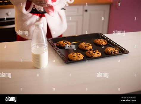 Santa Claus Eating Cookie And Drinking Milk At Christmas Stock Photo