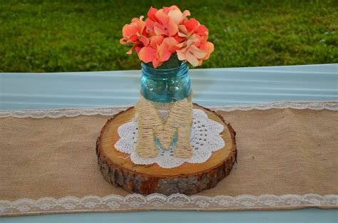 Mason Jar Centerpieces With Burlap And Lace Wraps Sitting On Log Slabs