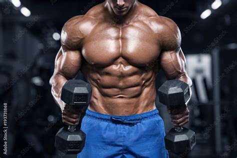 Muscular Man Working Out In Gym Doing Exercises With Dumbbells Strong