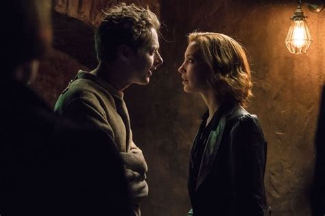 A Man And Woman Standing Next To Each Other In A Dark Room With Light