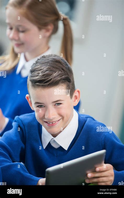Portrait Of Cheerful Schoolboy Wearing Blue School Uniform With Tablet