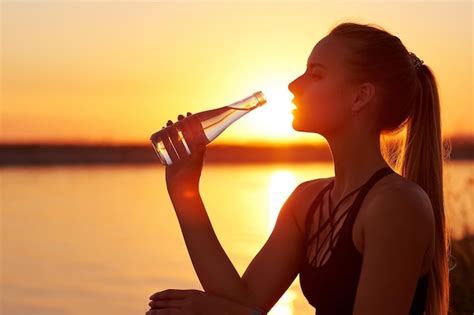 Premium Photo Silhouette Woman Drinking Water From Bottle After Run