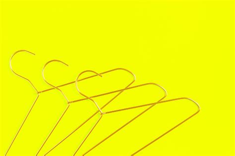 Three Wire Coat Hangers On Yellow Background Stock Photo Download