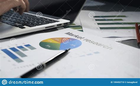 Office Table With Papers And Male Hands Typing In Laptop Stock Photo