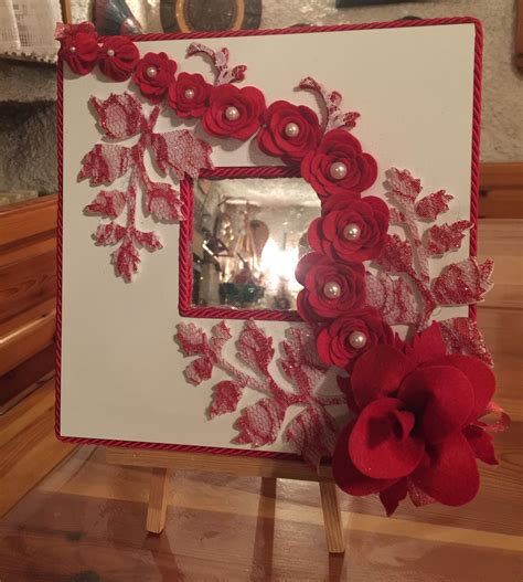Immagine dei bei alberi di fiori rossi. Specchio con tralcio di fiori rossi in pannolenci ...