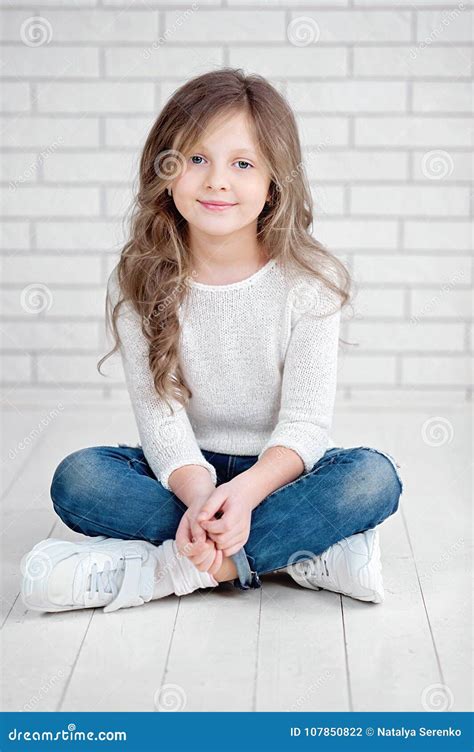Portrait Of Cute Little 7 Years Old Girl Smiling And Sitting On White