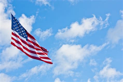 Premium Photo American Flag On A Blue Sky During A Windy Day