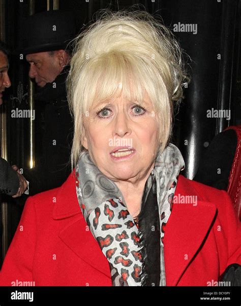 barbara windsor wearing a scarlet red coat leaves the wolseley restaurant in piccadilly london