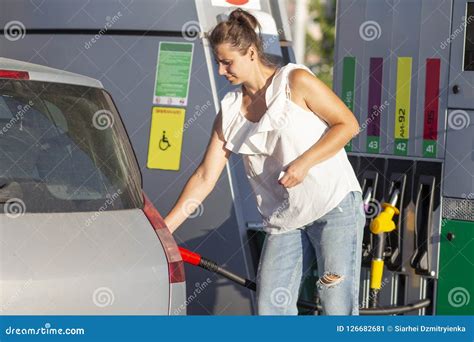Woman At Gas Station The Girl Pours Fuel Into The Tank Of The Machine