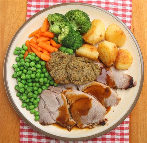 Traditional christmas food includes:christmas pudding, mince pies, brawn paté, asparagus soup, jerusalem artichokes, chocolate drops, blancmange, boozy. Sunday Roast Pork Dinner From Above Stock Photo - Image of ...