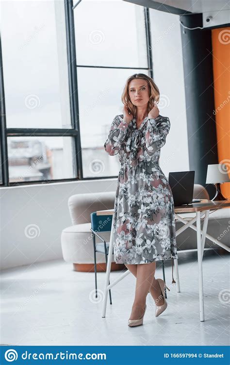 Cozy Office Businesswoman With Curly Blonde Hair Standing In Room
