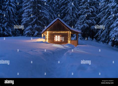 Fantastic Winter Landscape With Glowing Wooden Cabin In Snowy Forest