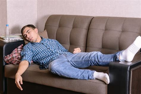 Premium Photo Sleeping Young Man On The Couch In The Room Tired After Work Drunk After A Party