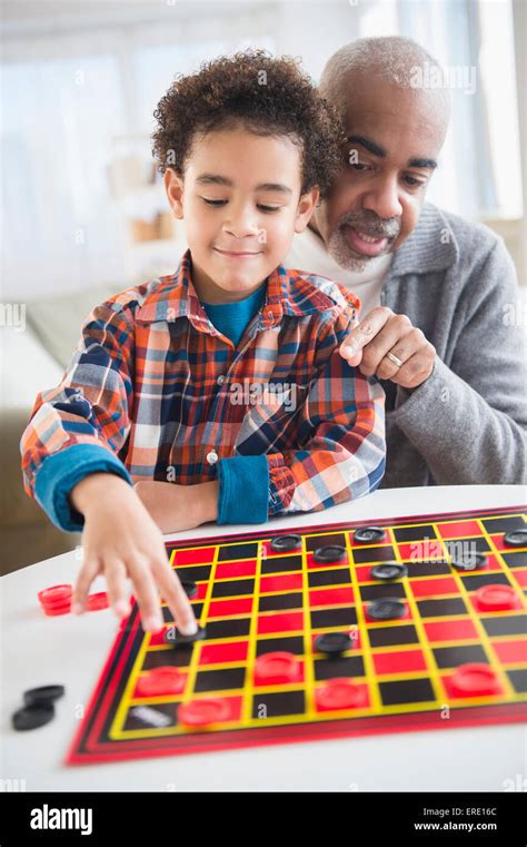 Mixed Race Grandfather And Grandson Playing Checkers Stock Photo Alamy