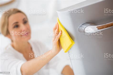 Pretty Blonde Housewife In White Shirt Cleaning The Fridge And Looking