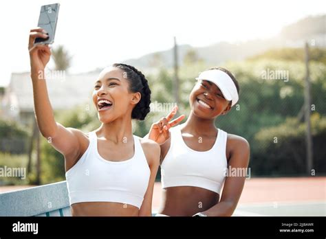 We Look Exactly Like Winners Two Sporty Young Women Taking Selfies Together On A Tennis Court