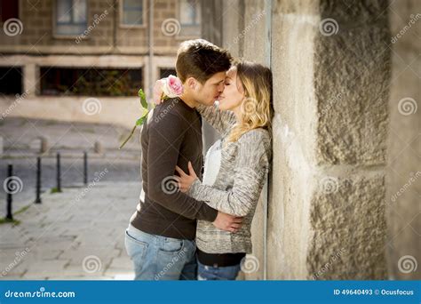 Candid Portrait Of Beautiful European Couple With Rose In Love Kissing