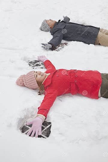 Young Couple Laying In Snow Making Snow Angels Stock Image Image Of