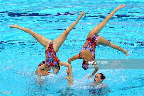 Two Women In The Water Doing An Acrobatic Move On Their Hands And Legs