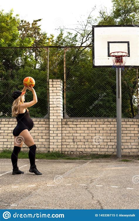 Pregnant Girl On The Basketball Court Throws The Ball Into The Ring
