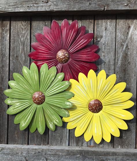 This handcrafted metal flower wall art boasts exquisite dimension from different petal layers backed by an espresso metal outline and wood outline details. 12 Metal Flowers / Garden Daisy Wall Flowers / Set of 3