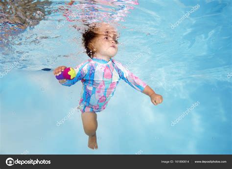 Маленькая девочка учится плавать под водой в бассейне стоковое фото ©uw