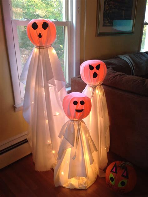 Two Paper Lanterns With Faces On Them Sitting In Front Of A Window One