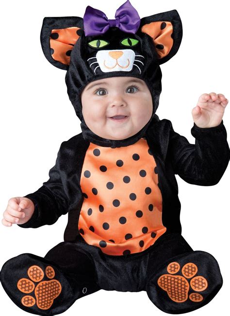A Baby In A Costume Sitting On The Ground With Its Hands Up And Eyes Closed