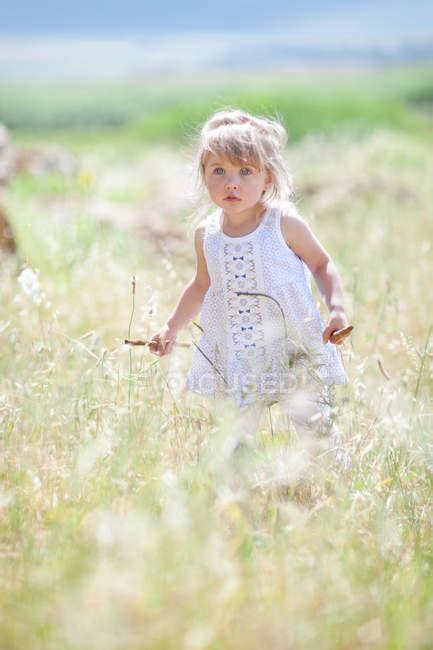 Girl Walking In Tall Grass — Sunlight Serious Stock Photo 165512596
