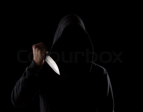 A Dangerous Hooded Man Standing In The Dark And Holding A Shiny Knife Face Can Not Be Seen