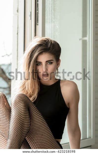 Beauty And Fashion Pretty Girl Or Sexy Woman With Stylish Long Hair Sitting With Legs On White