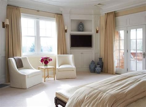 Elegant Master Bedroom Features A Bed Facing A Small Sitting Area