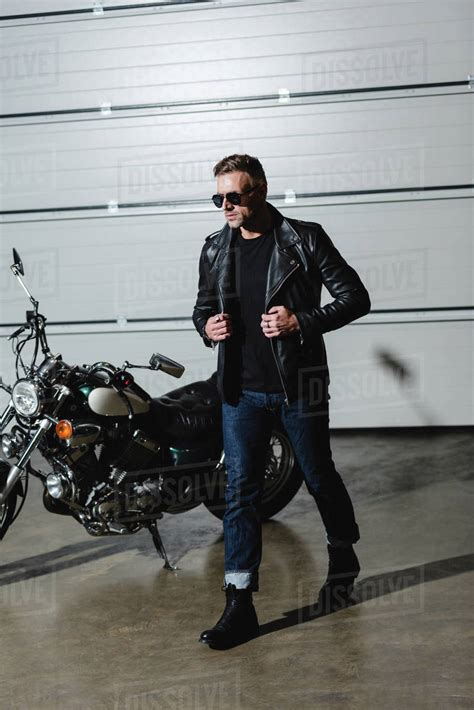Cool Guy In Sunglasses And Leather Jacket Walking In Garage Stock