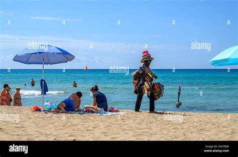 Ein schwarzer afrikanischer Strandverkäufer läuft am Ende der Saison unter Sonnenanbetern