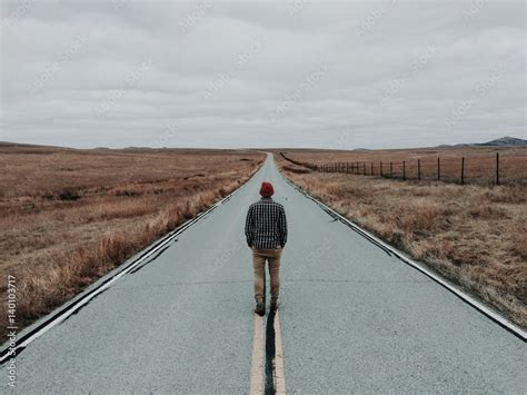 Man Standing In Middle Of Road By Fields Rear View Stock Photo Adobe