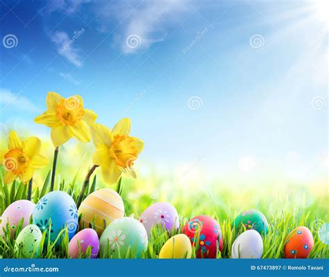 Daffodils And Colorful Decorated Eggs On The Sunny Meadow Easter